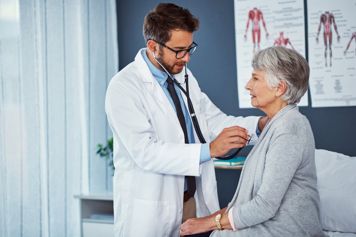 Médico examinando a un paciente mayor en una clínica