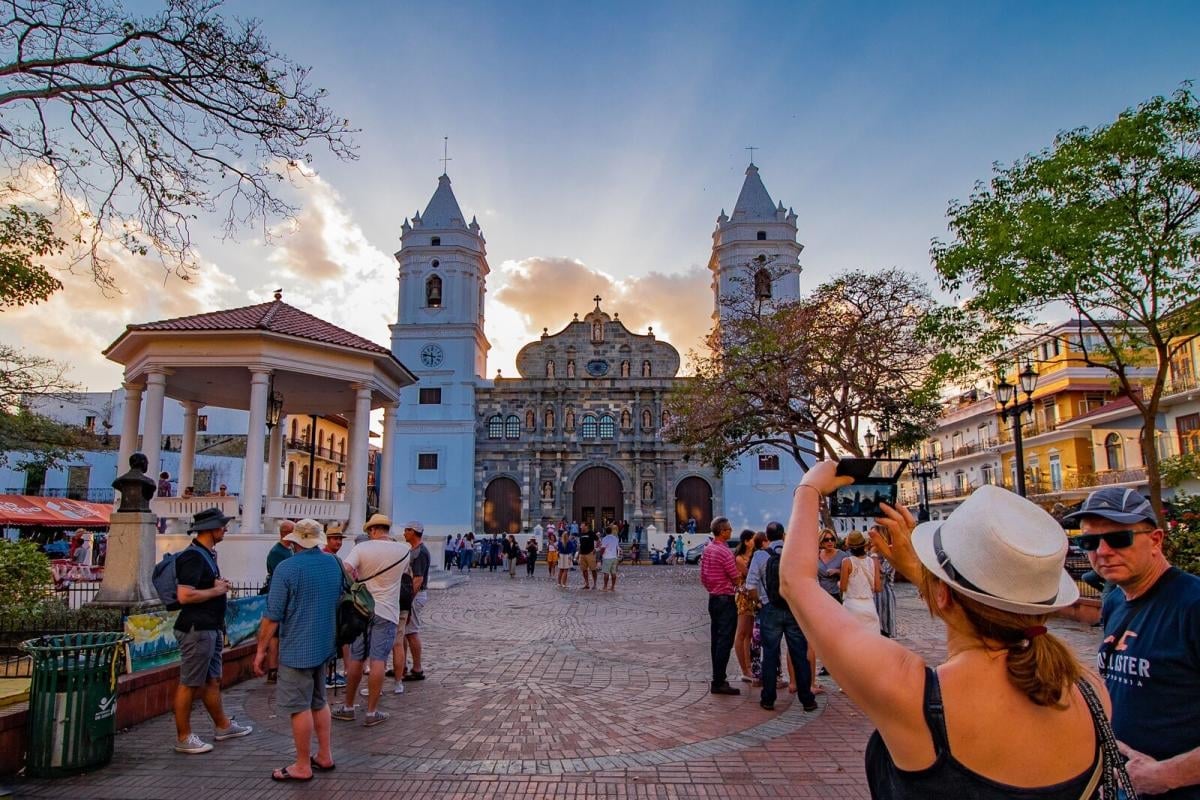 Tourists photographing the Cathedral plaza in Casco Antiguo, Panama City, at sunset